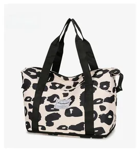 Detail of travel tote bag featuring leopard print fabric and durable woven handles