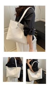 Detail view of large white tote bag with woven texture and long shoulder straps