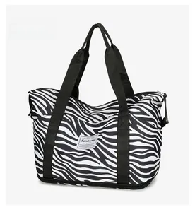 Detail of waterproof zebra print oxford fabric travel bag with reinforced stitching handles