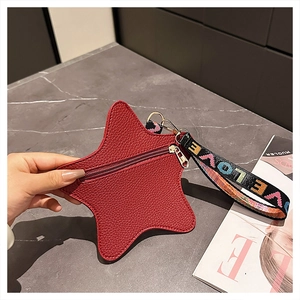 Detail of red star-shaped purse with pebble texture leather and LOVE webbing strap