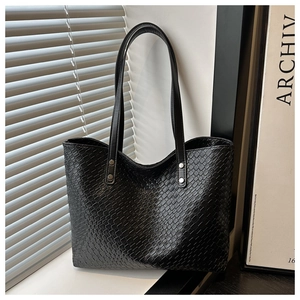 Detail of black woven tote bag with silver metal ring buckle and faux leather texture
