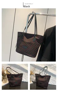 Détail d'un grand sac cabas noir à motifs de cœurs rouges avec un nœud en tulle latéral