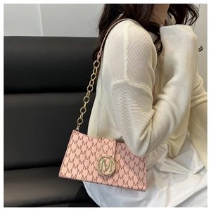 Détail du sac bandoulière rose avec logo M doré et chaîne sur le mannequin