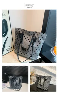 Détail du sac cabas gris foncé à pois avec un grand nœud en dentelle noire et logo