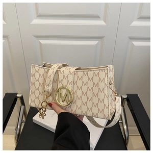 Détail du sac rectangulaire avec imprimé monogramme et boucle dorée en forme de M