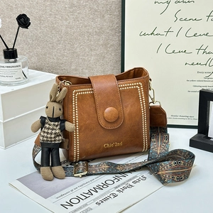 Brown vintage leather bucket bag with wide ethnic strap and cute bunny pendant