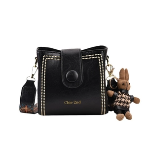 Black pebbled leather crossbody bucket bag with gold studs and colorful strap