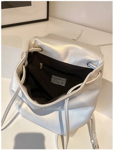 Detailansicht eines perlweißen Lederrucksacks mit Kordelzug und schwarzem Innenfutter