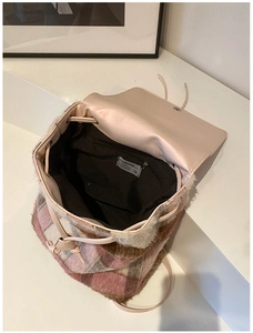 Detailansicht eines rosa karierten Plüschrucksacks mit geräumigem Innenraum und Zippfach