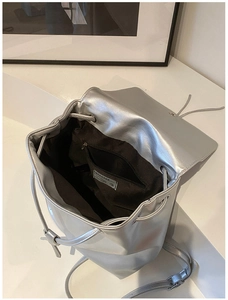 Detailansicht silberne Metallic-Tasche mit Kordelzug und braunem Stoff-Innenfutter