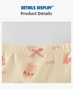 Close-up of yellow cotton girls' underwear featuring pink cat patterns and a ribbon bow