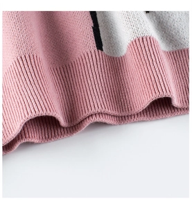 Detalle del dobladillo acanalado en jersey de punto infantil en rosa suave y blanco