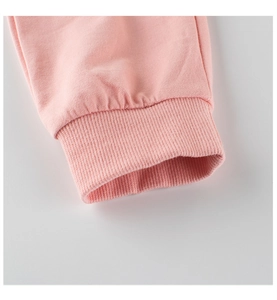 Close-up of pink knitted sports pants showing ribbed cuffs and soft fabric texture