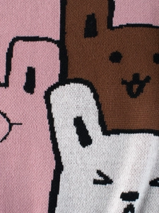 Jersey de punto para niños con un lindo patrón de conejo rosa en primer plano suave
