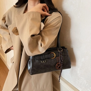 Minimalist black leather pillow bag for women with golden buckle and vintage strap detail