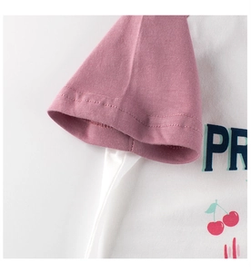 Détail des manches raglan et de l'imprimé cerise sur le t-shirt en coton pour enfant