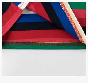 Vue macro d'un ourlet en coton à rayures colorées avec détails de couture à double aiguille