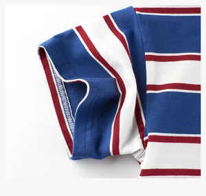 Macro detail of red and blue striped cotton T-shirt sleeve with precise edge stitching