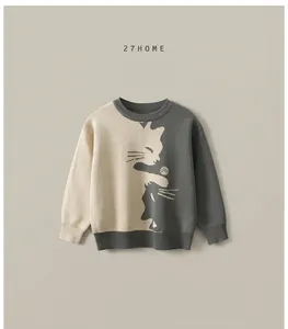 Detailed view of color-block knit sweater with cat jacquard and ribbed cuffs for kids