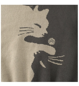 Close-up of knit fabric showing abstract cat pattern and thick jacquard texture