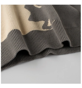 Detailed macro view of the ribbed knit hem and contrast color pattern on this sweater