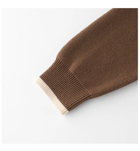 Detailed view of the dark brown knitted sweater with cream ribbed cuffs for girls