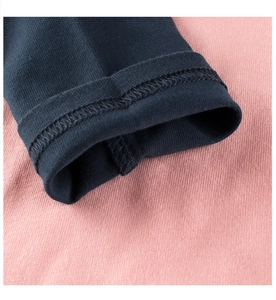 Dettaglio manica in maglia rosa con polsino blu e finitura con doppia cucitura di qualità