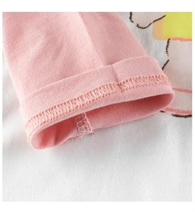 Gros plan sur l'ourlet roulé rose de la manche d'un t-shirt en coton pour tout-petit