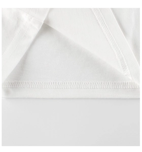 Détail de l'ourlet en coton avec double couture robuste sur le t-shirt blanc pour enfant