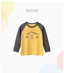 Detail of raglan sleeves and cute cartoon bear print on a mustard yellow kids t-shirt