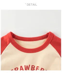 Détail du col rond rouge et des manches raglan sur le t-shirt imprimé fraise