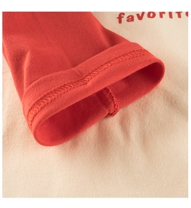 Vue macro du poignet en tricot avec lettrage rouge favorite et détails de couture
