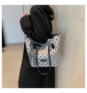 Sac fourre-tout en toile à pois avec nœud en dentelle noire porté à l'épaule