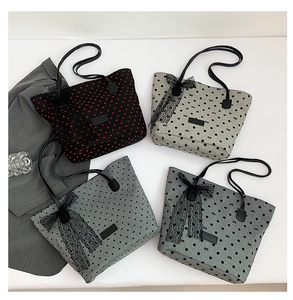 Vista piatta di borse tote a pois con fiocchi in pizzo in nero, grigio e verde acqua