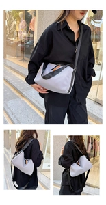 Détail du sac bandoulière en nylon lilas avec sangle noire et tirette de zip orange