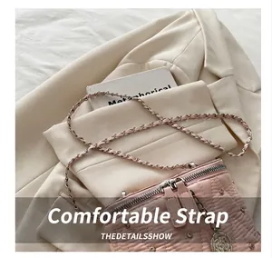 Dettaglio borsa trapuntata rosa con ciondolo rosa e borchie argentate su blazer beige