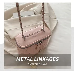 Dettaglio ravvicinato della mini borsa rosa trapuntata con borchie e tracolla a catena