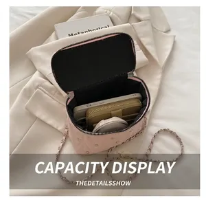 Vista interna che mostra la capienza della borsa a scatola rosa trapuntata con borchie e catena