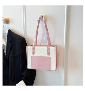 Close-up of pink and beige patchwork tote bag with checkered texture hanging on a wall