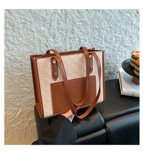 Close-up of color-block tote bag featuring checkered texture and front leather pocket