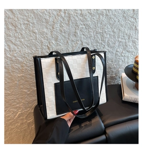 Detail of black and white tote bag with checkerboard texture and front pocket