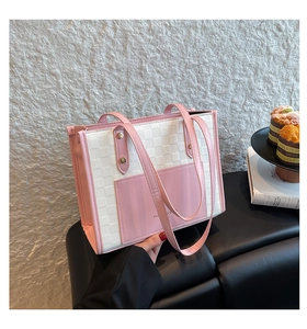 Detail of pink and beige checkered tote bag with gold rivets and front pocket