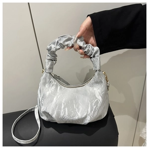 Close-up of silver pleated cloud bag showing metallic texture and gathered handle