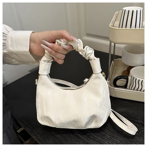 Detailed close-up of a white pleated cloud hobo handbag with a soft leather texture