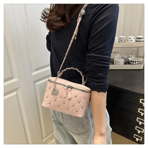 Quilted pink box bag with silver studs and chain strap shown on model for scale