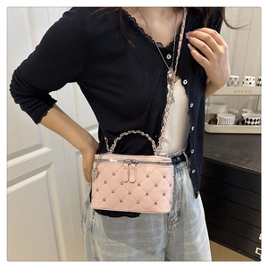 Detail of pink quilted box bag with chain strap and sparkling rhinestone accents