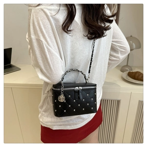 Quilted black crossbody bag featuring silver studs and camellia flower charm detail