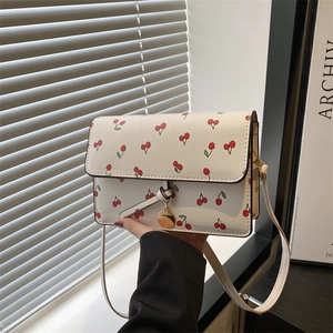 Sac bandoulière blanc avec imprimés cerises et breloque anneau doré au style rétro