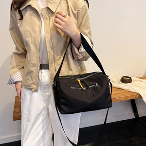 Waterproof black nylon crossbody bag with dual pockets and yellow decorative zipper strap