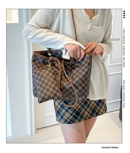 Detail of vintage checkered tote bag with matching pouch and brown leather handles